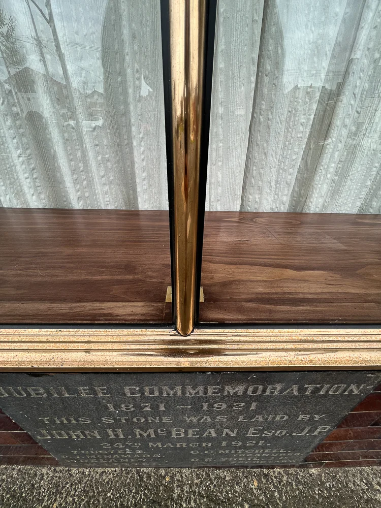 Copper sill and central frame at the base of the shopfront glazing