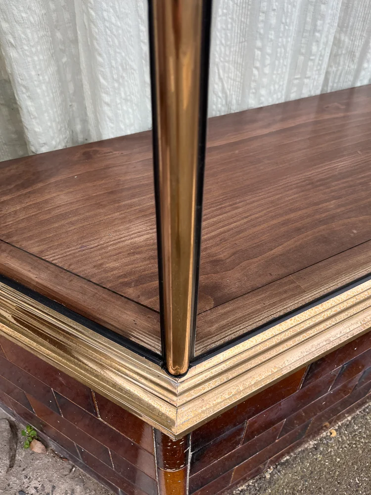 Shaped copper moulding wrapping a lower shopfront window corner