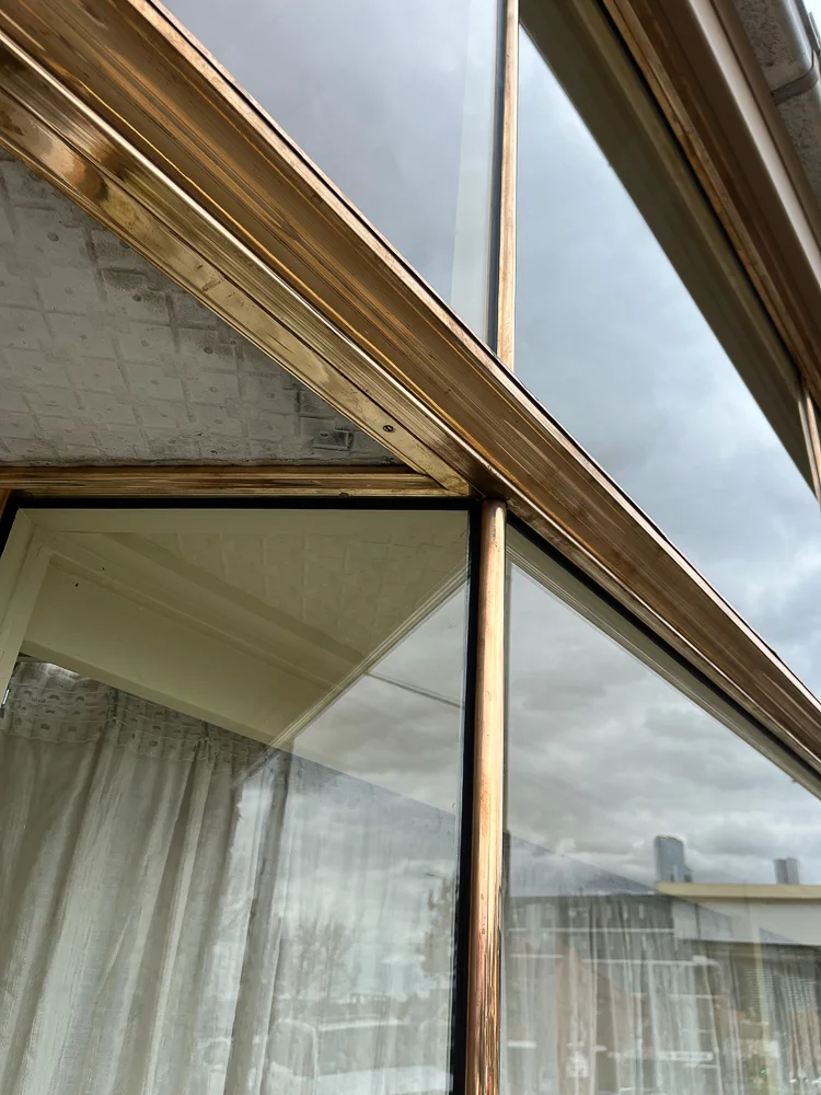 Close view of a copper shopfront window corner and upper frame